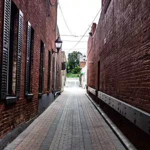 A narrow alley with a brick wall.