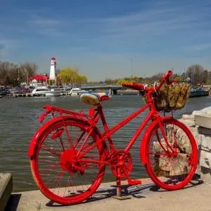 A red bicycle parked near a body of water. A red bicycle parked near a body of water.