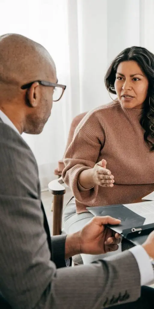 A woman talking to a man in an office. A woman talking to a man in an office.